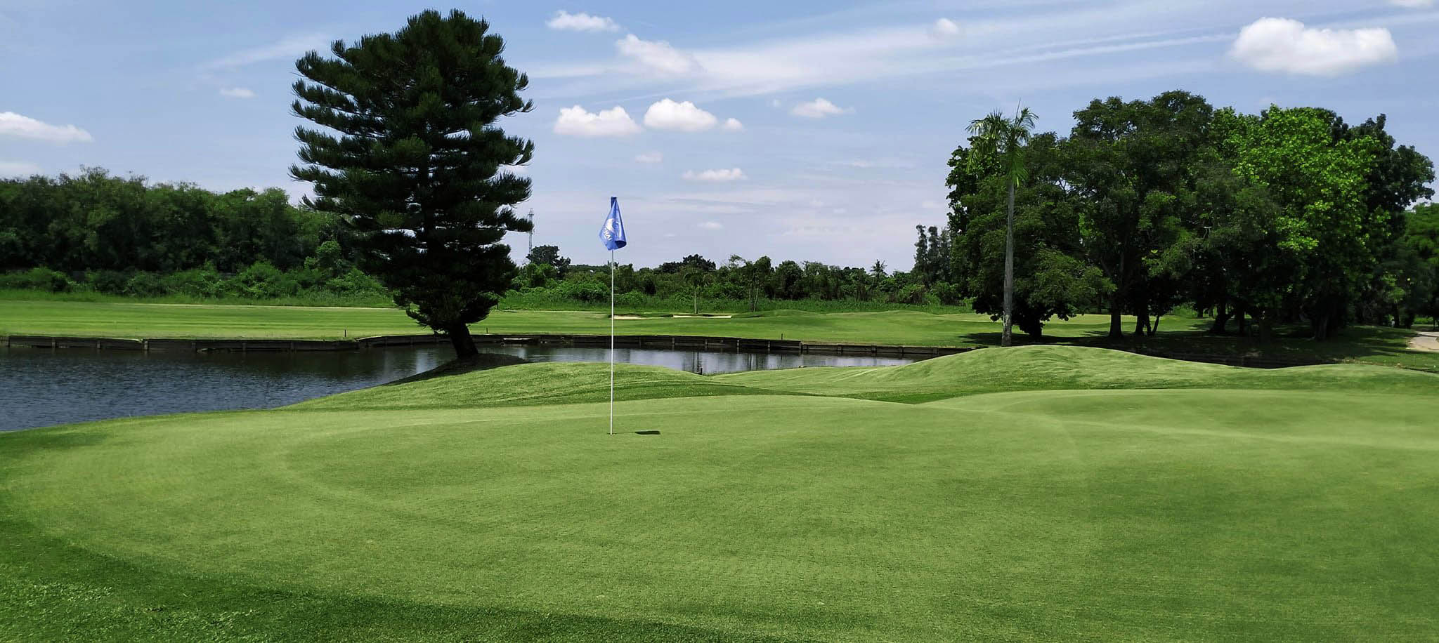 Ekachai-course-view-blue-sky-green-water-hazard.jpg